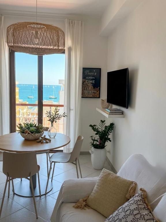 a living room with a table and a view of the ocean at Casa della Civetta in Monopoli