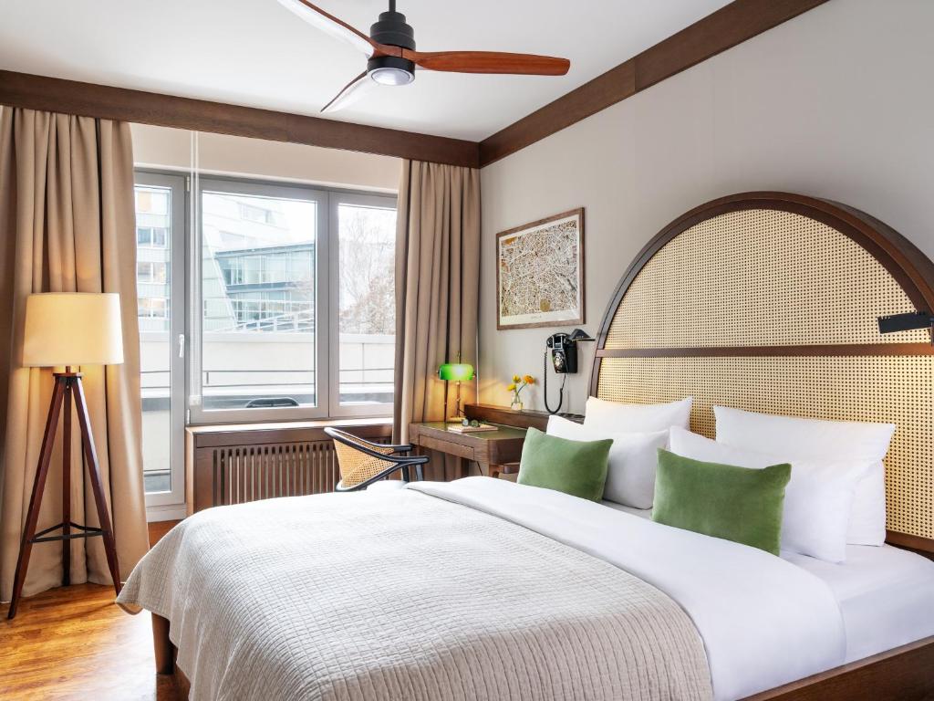a bedroom with a large bed with green pillows at Numa Berlin Potsdamer Platz in Berlin
