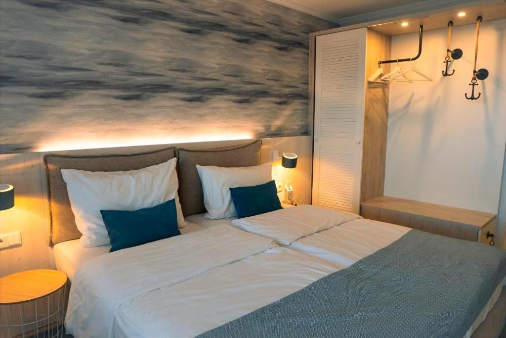 a bedroom with a large bed with a painting on the wall at Hotel Haus am See in Lembruch
