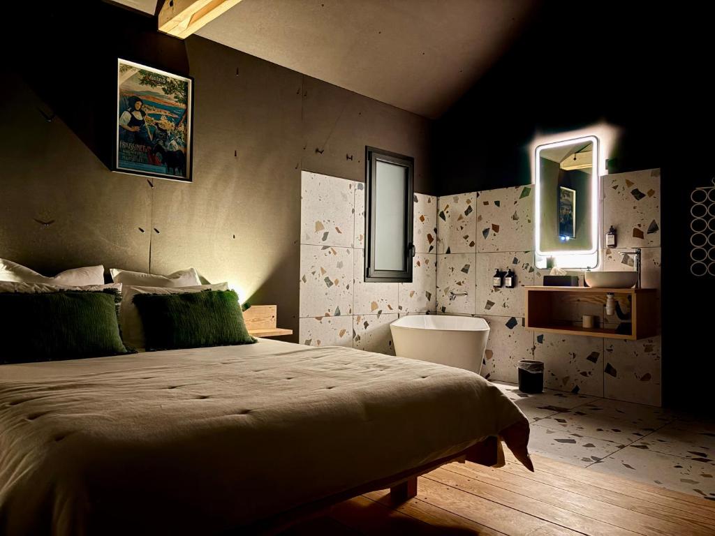 a bedroom with a large bed and two mirrors at Le Vert d'Orezza in Valliquerville