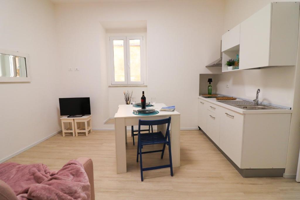 a kitchen with a small table and a kitchen with white cabinets at Penelope's House in Otranto in Otranto