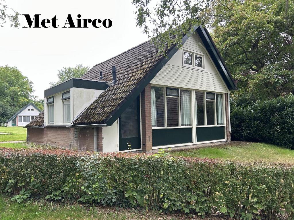 a small house with a gambrel roof at Huisje 118 bungalowpark Simpelveld in Simpelveld