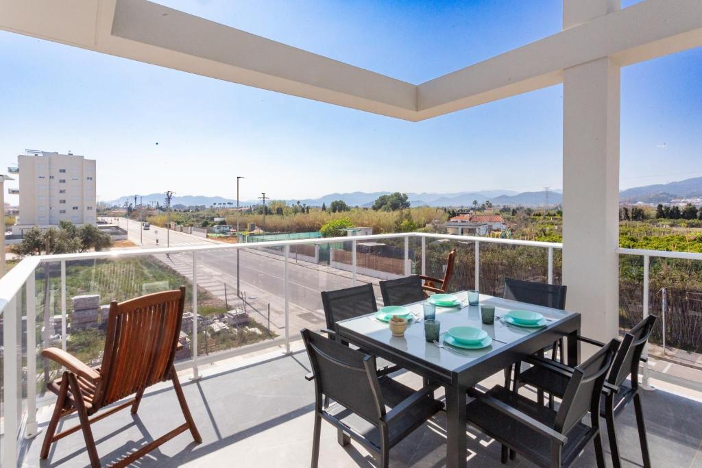 a dining room with a table and chairs on a balcony at AT Ponent II B3 in Oliva