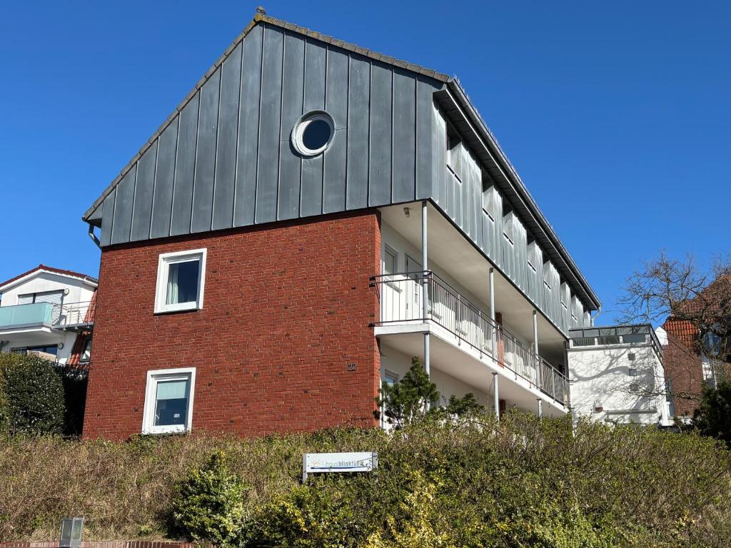 a red brick building with a grey roof at Haus Blinkfüer in Wangerooge
