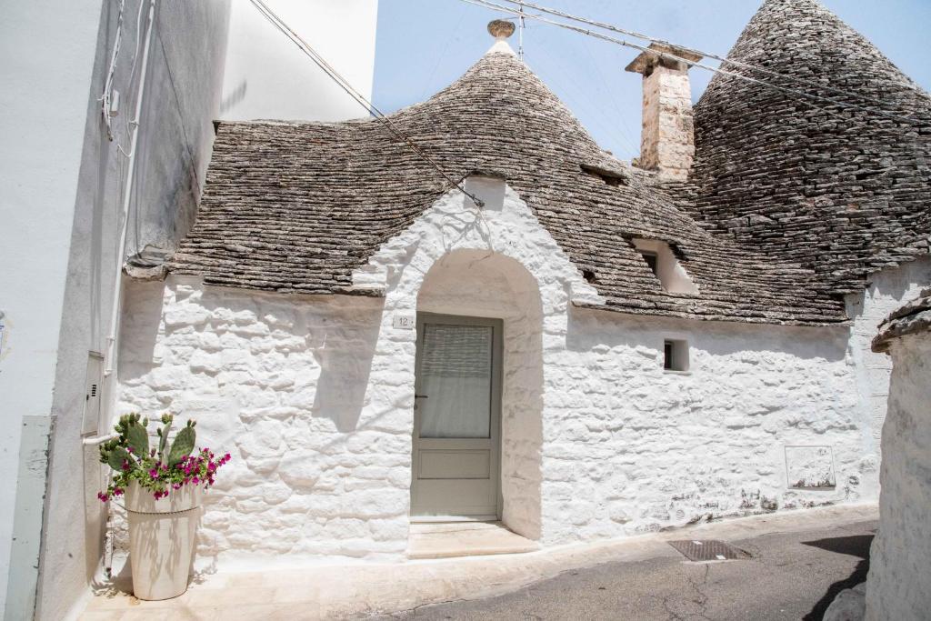 a white building with a door and a roof at Trullo Fico d'India in Alberobello