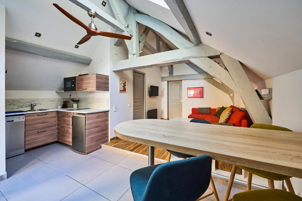 a kitchen and dining room with a table and a couch at Le Bossuet - Cosy et Charme au Centre Historique in Dijon