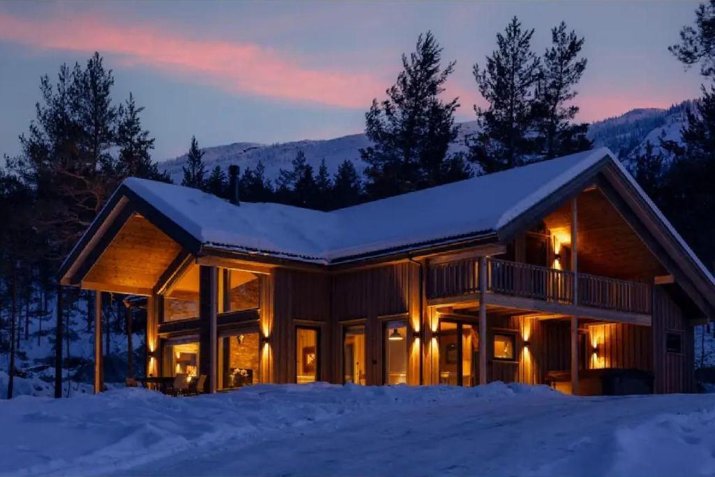 a log home in the snow at dusk at Lakelodge 10p in Vradal