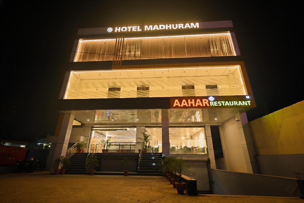 a hotel madhubanadi is lit up at night at Madhuram Hotel in Ayodhya