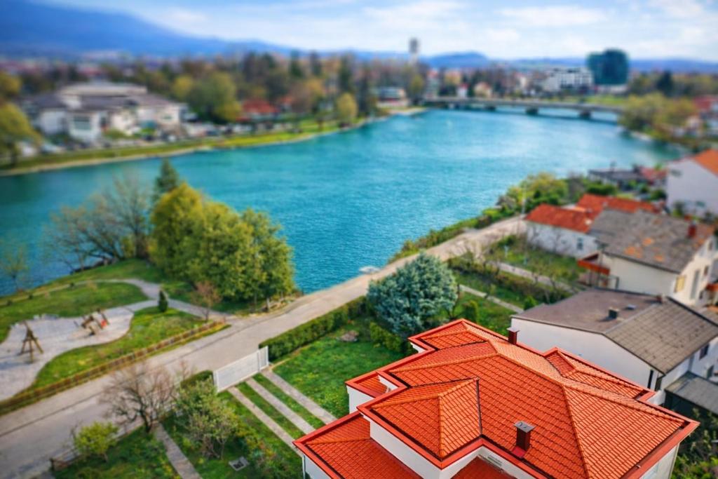 an orange roofed building next to a river at Vila Najla in Bihać