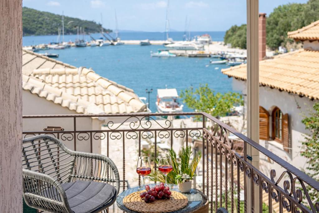 a balcony with a table and two glasses of wine at Esperides Studios-Seaside Stay with View in Syvota in Syvota