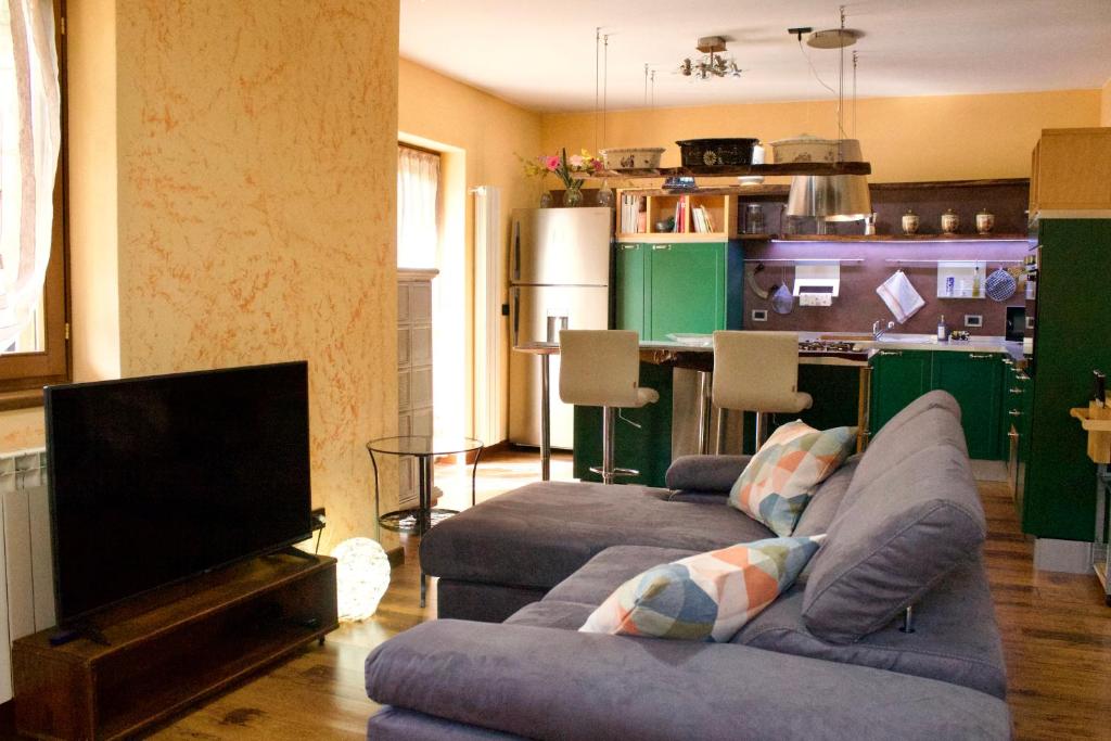 a living room with two couches and a kitchen at Tra le Alpi - Holiday House in Tresivio