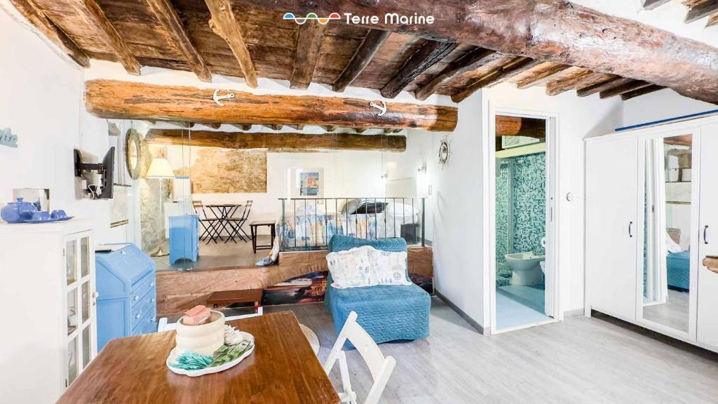 a living room with a table and a blue chair at Rio Alba Blue, Terre Marine in Riomaggiore