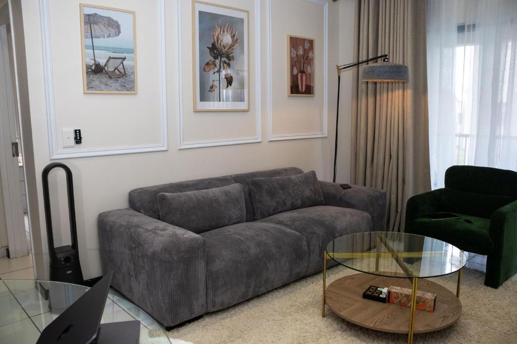 a living room with a couch and a glass table at Luxury Sunset Gem with Power Backup in Sandton