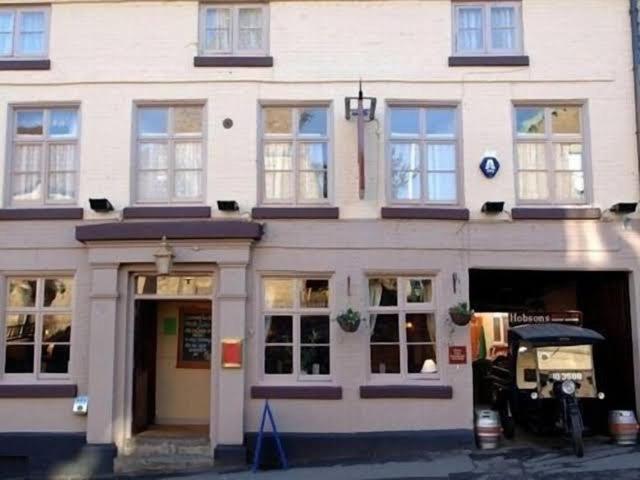 a large white building with a store in front of it at The Kings Arms in Cleobury Mortimer