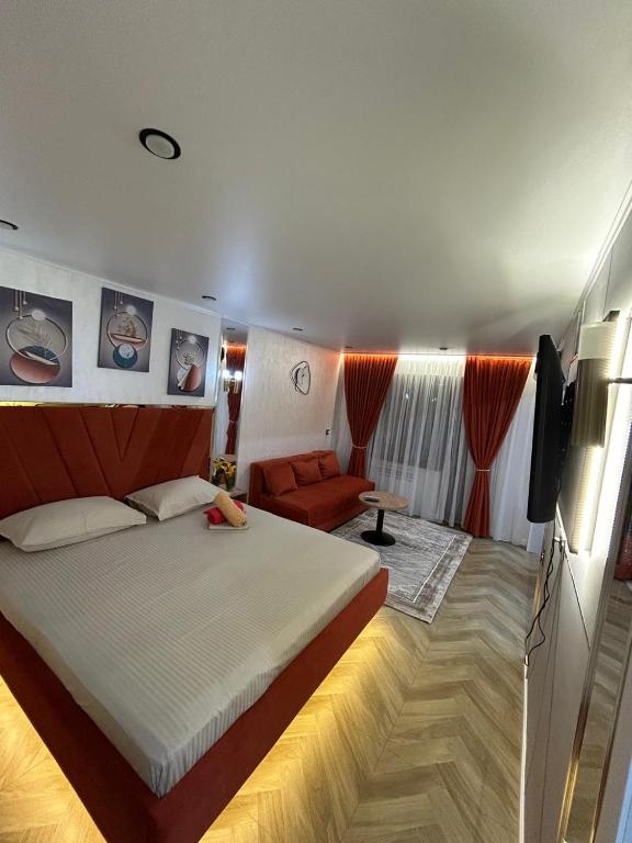 a bedroom with a large bed and a television at Korkyt in Qyzylorda