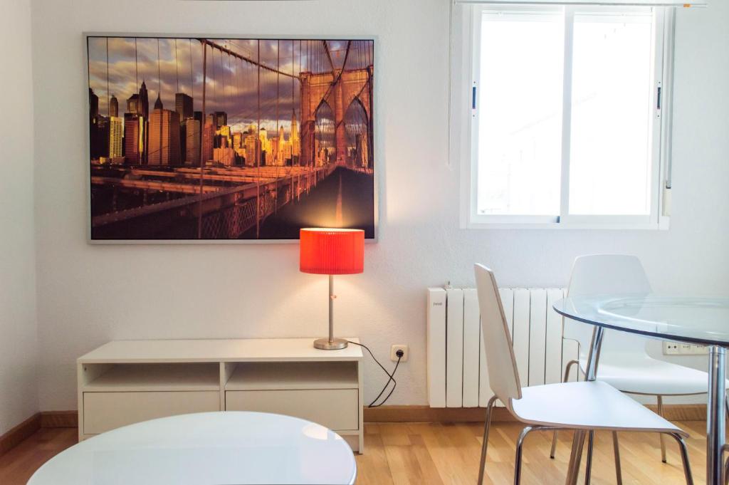 un comedor con una mesa y una pintura en la pared en For You Rentals reina sofia apartment DF21, en Madrid