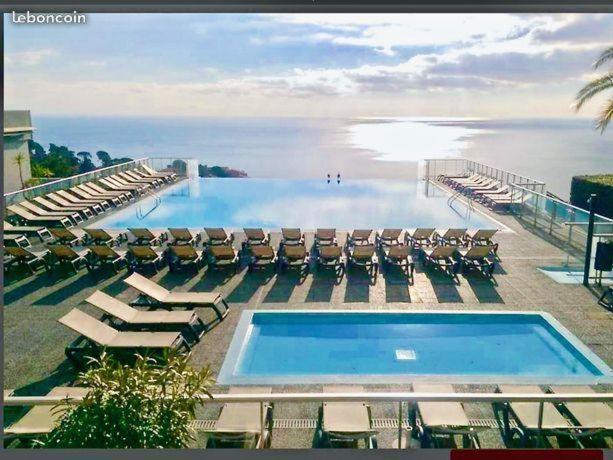 a swimming pool with chaise lounges and chairs at COSTA PLANA COLLECTION - Cap d'Ail - Monaco in Cap d'Ail