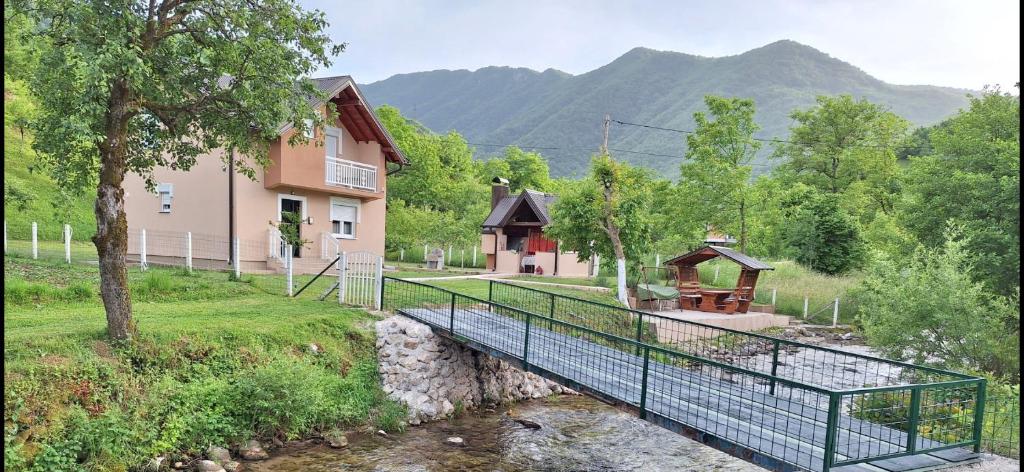 a bridge over a river next to a building at Vila-kuca"Jasmin"pored rijeke i jezera in Konjic