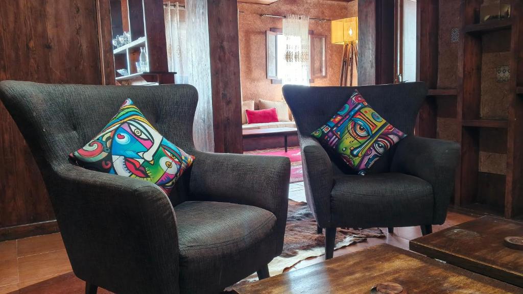 two chairs in a living room with pillows on them at Antic house in Agadir