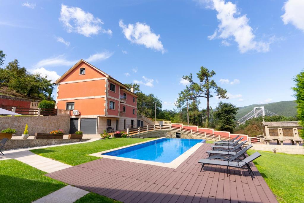a backyard with a swimming pool and chairs and a house at Lar de Sefa 15 in Redondela