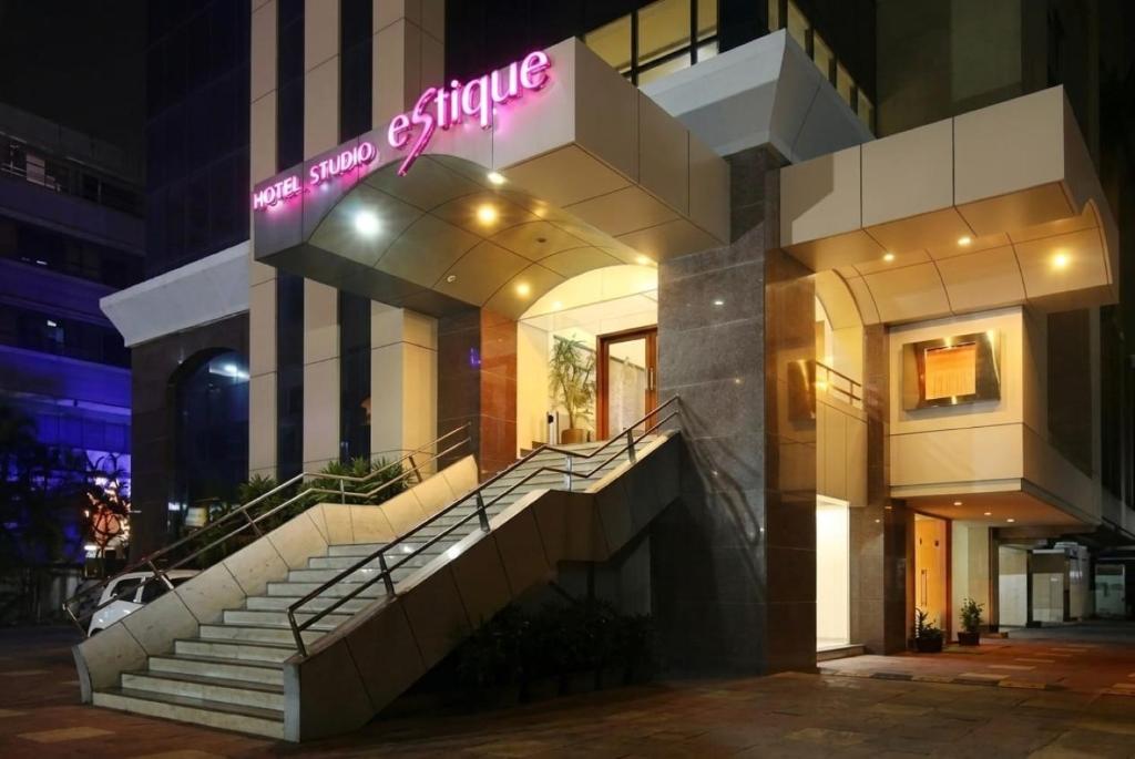 a building with stairs and a sign on it at Hotel Studio Estique in Pune