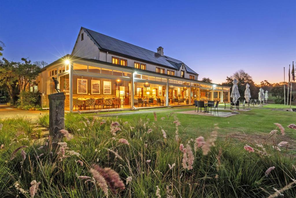 a large building with a lawn in front of it at Gowrie Farm Golf Lodge in Nottingham Road