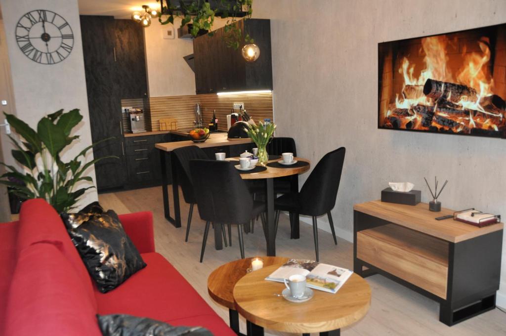 a living room with a red couch and a table at Apartament SANOVA 50 in Sanok