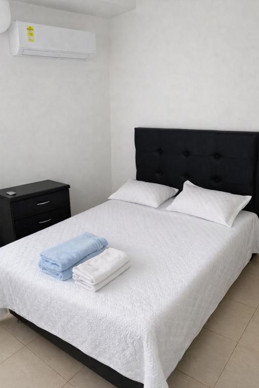 ein Schlafzimmer mit einem großen Bett, auf dem zwei Handtücher liegen in der Unterkunft entresierras in Valledupar