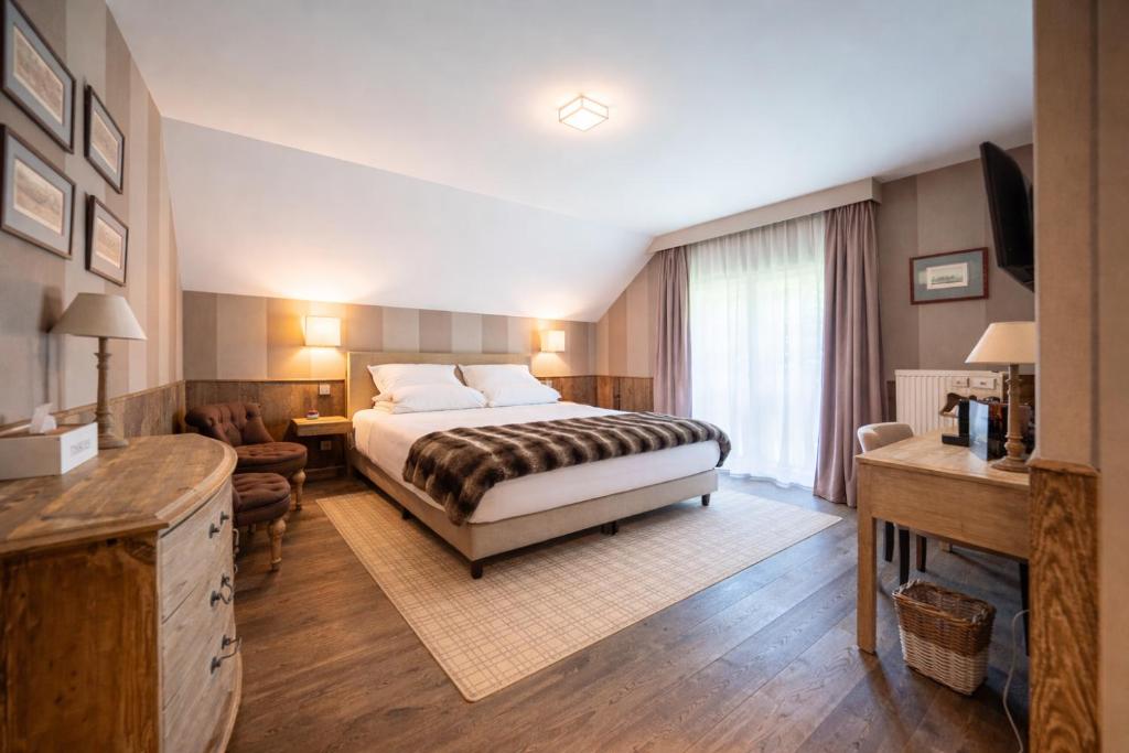 a bedroom with a bed and a living room at La Barrière de Transinne in Libin