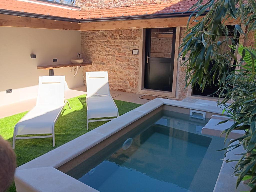 two chairs and a swimming pool in a house at Retiro do Lavrador in Alvaiázere