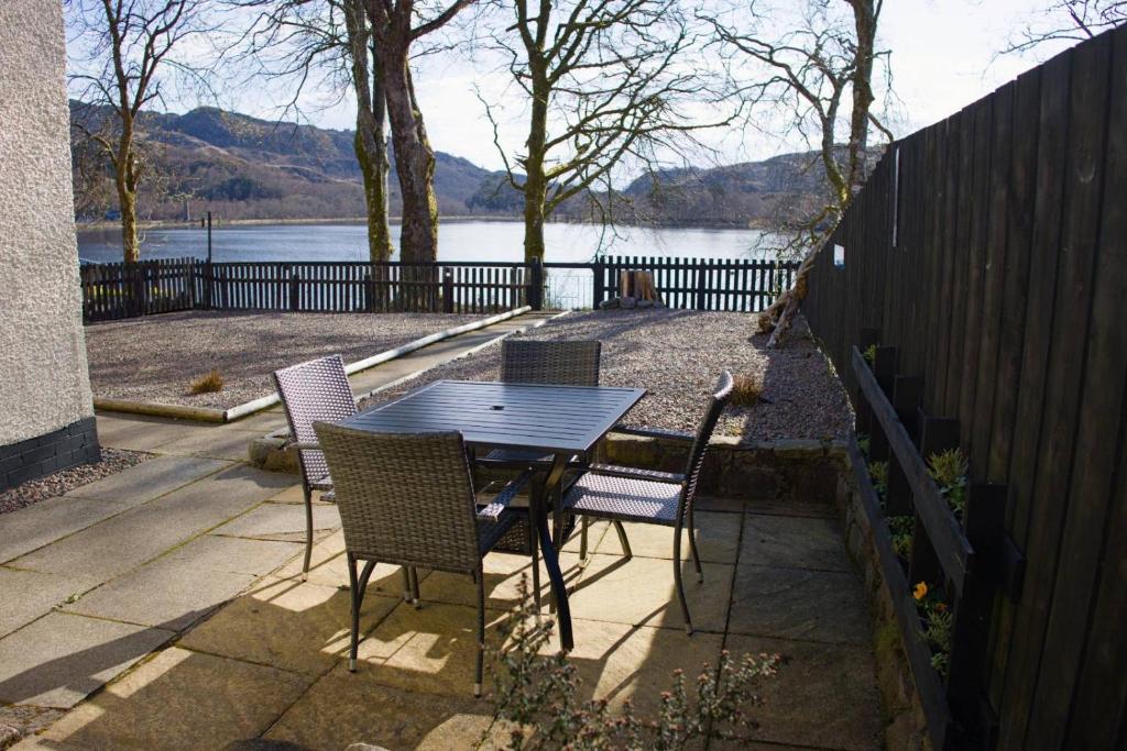 a table and chairs with a view of a lake at Number 4, Loch Shiel View in Glenfinnan