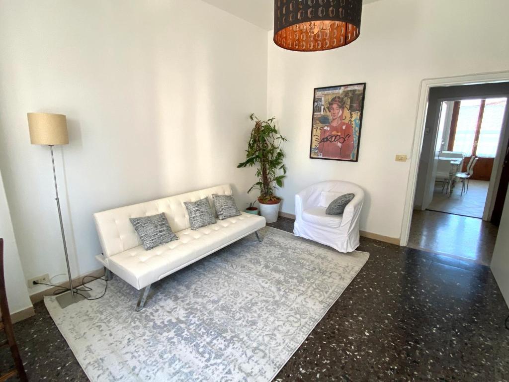 a living room with a white couch and a rug at Casa Carmen Vicchio, natura vicino a stazione e Mugello Circuit in Vicchio