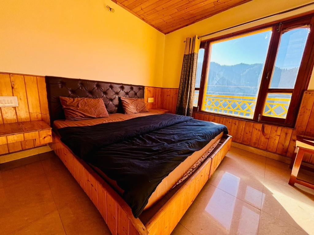 a bed in a room with a large window at Misfits Hostel and Cafe in Shoja