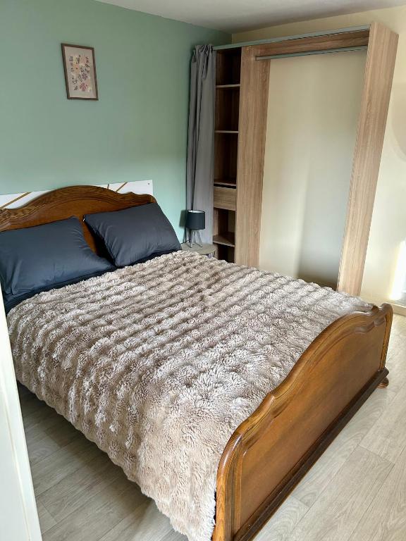 a bedroom with a large bed with a wooden frame at Studio cosy 71 in Saint-Vallier