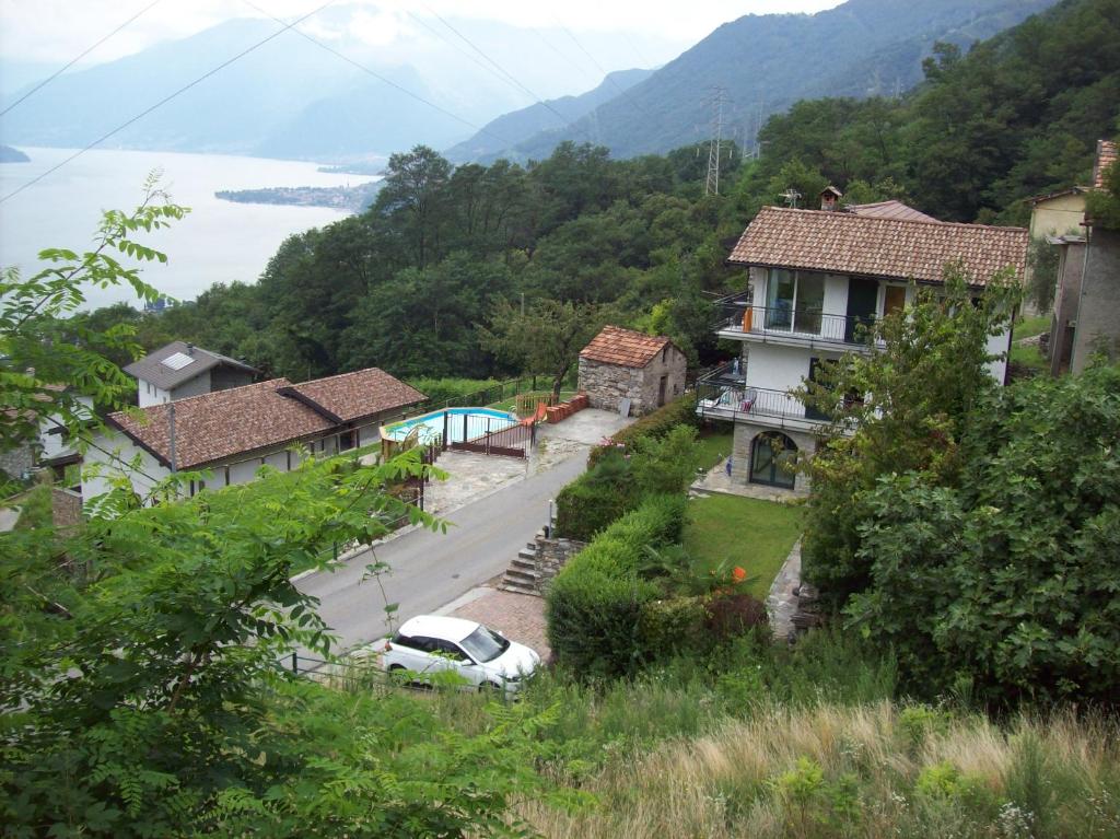 a house on a hill with a car parked in front at Casa delle Camelie in Sorico