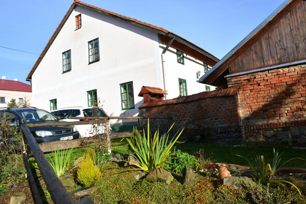 a white house with a car parked in front of it at Chalupa Hyršov in Hyršov