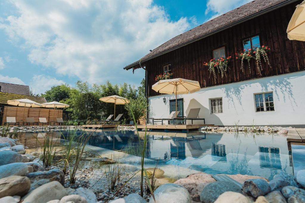 a house with a swimming pool in front of a building at Der Schlosswirt zu Anif - Biedermeierhotel und Restaurant in Anif