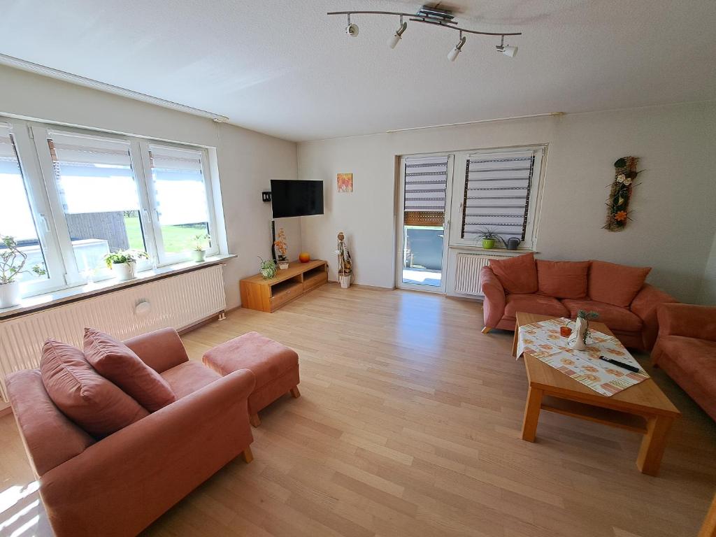 a living room with two couches and a table at Ferienwohnung Lene im Lauertal - Rhön in Maßbach