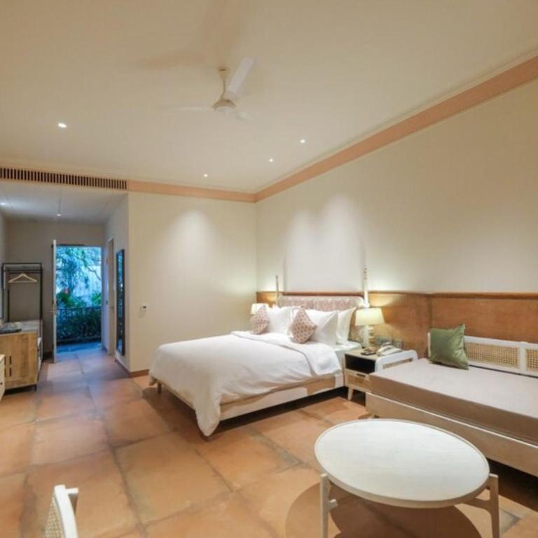 a bedroom with a bed and a table and a couch at The Forresta Checks-In, Jaipur in Jaipur