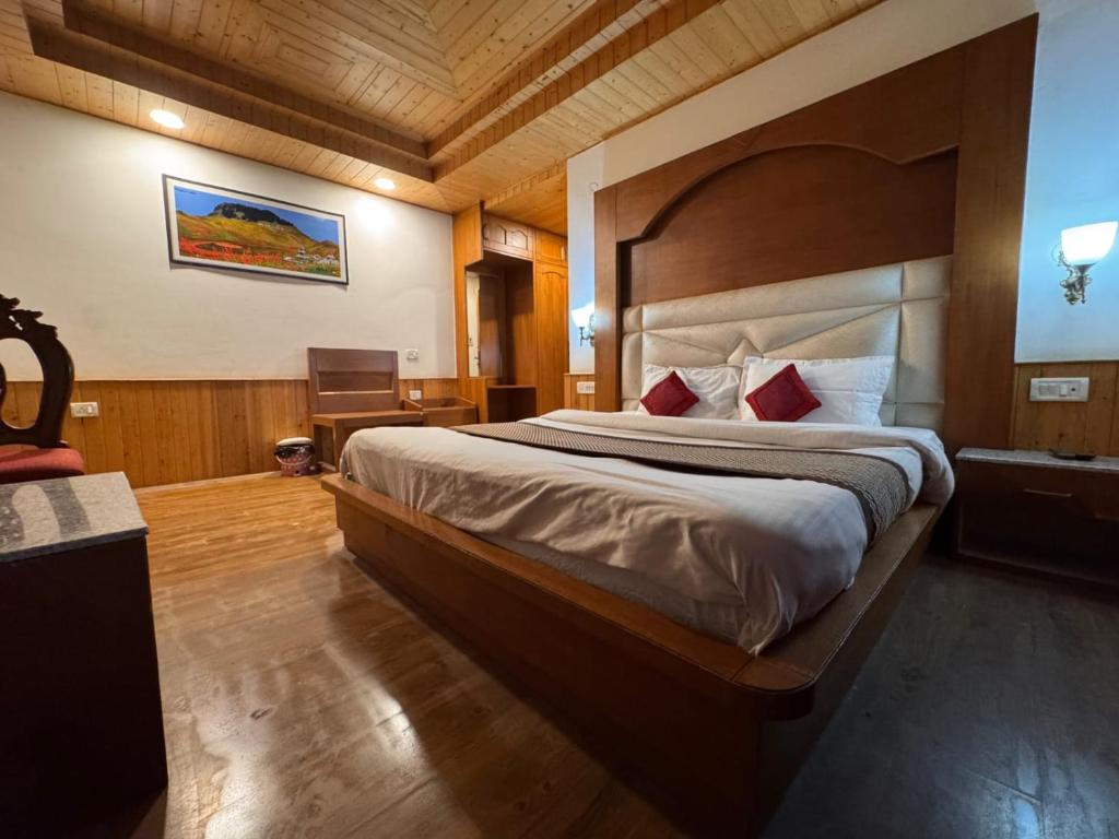 a bedroom with a large bed in a room at Hotel The Red Apple in Manāli