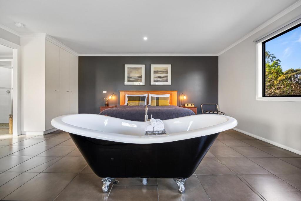 a bath tub in a bedroom with a bed at Blaze Rock Retreat in Halls Gap