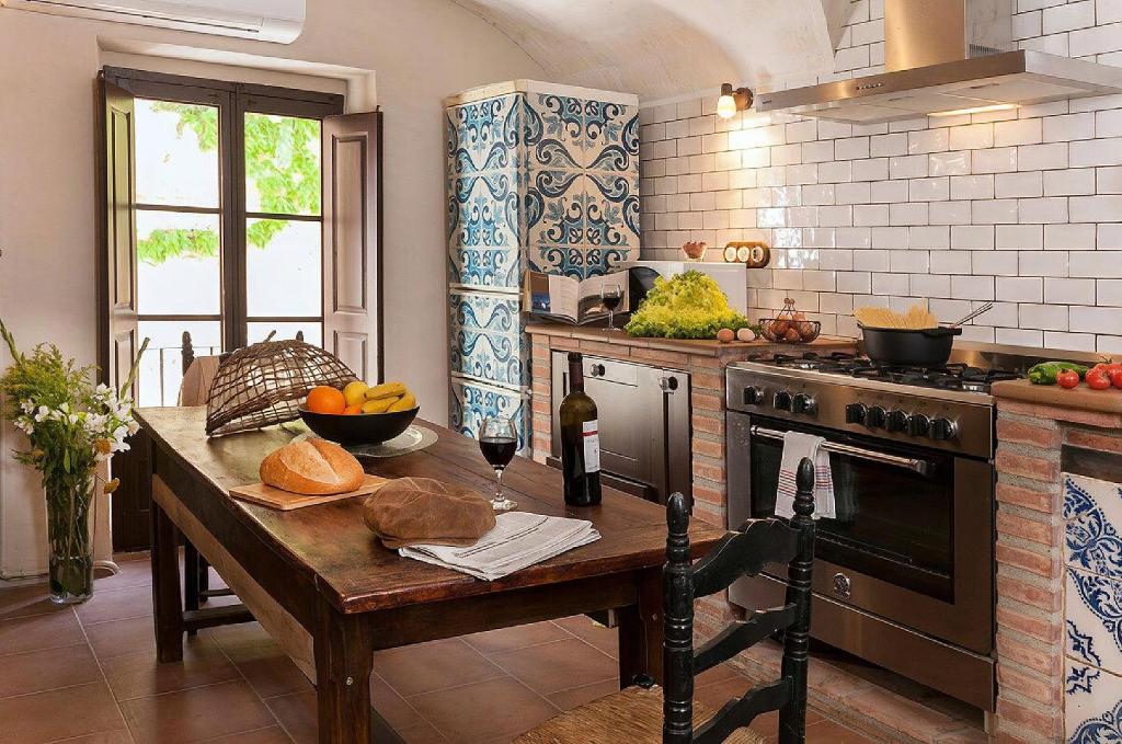 a kitchen with a wooden table and a stove at VentallóLEscala. WiFi. Rooftop w stunning views in Ventalló