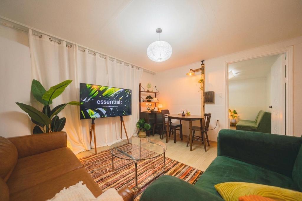 a living room with a couch and a flat screen tv at Cozy 2 6 Guest Stay near Gangnam 6 min from Nakseongdae Station in Samgong
