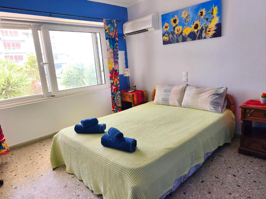 a bedroom with a bed with blue towels on it at Studio By the Beach in Saronida