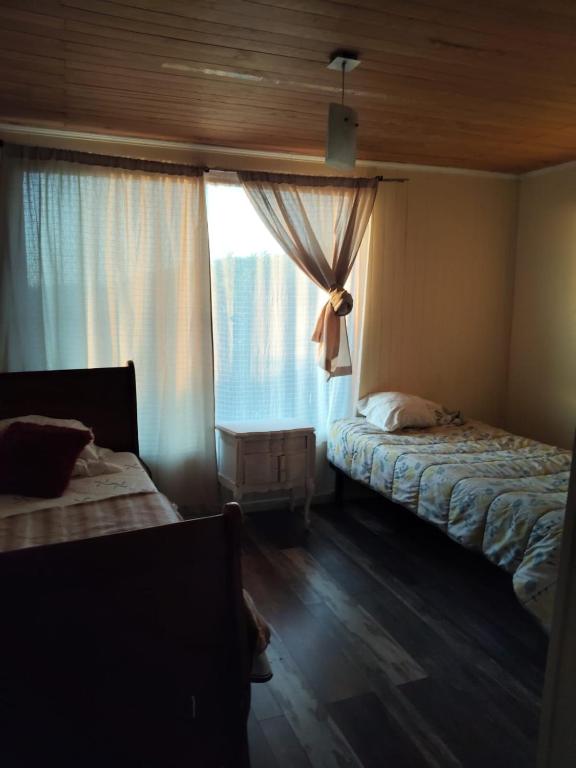 a bedroom with two beds and a window at Casa concon mascotas estacionamiento in Valparaíso