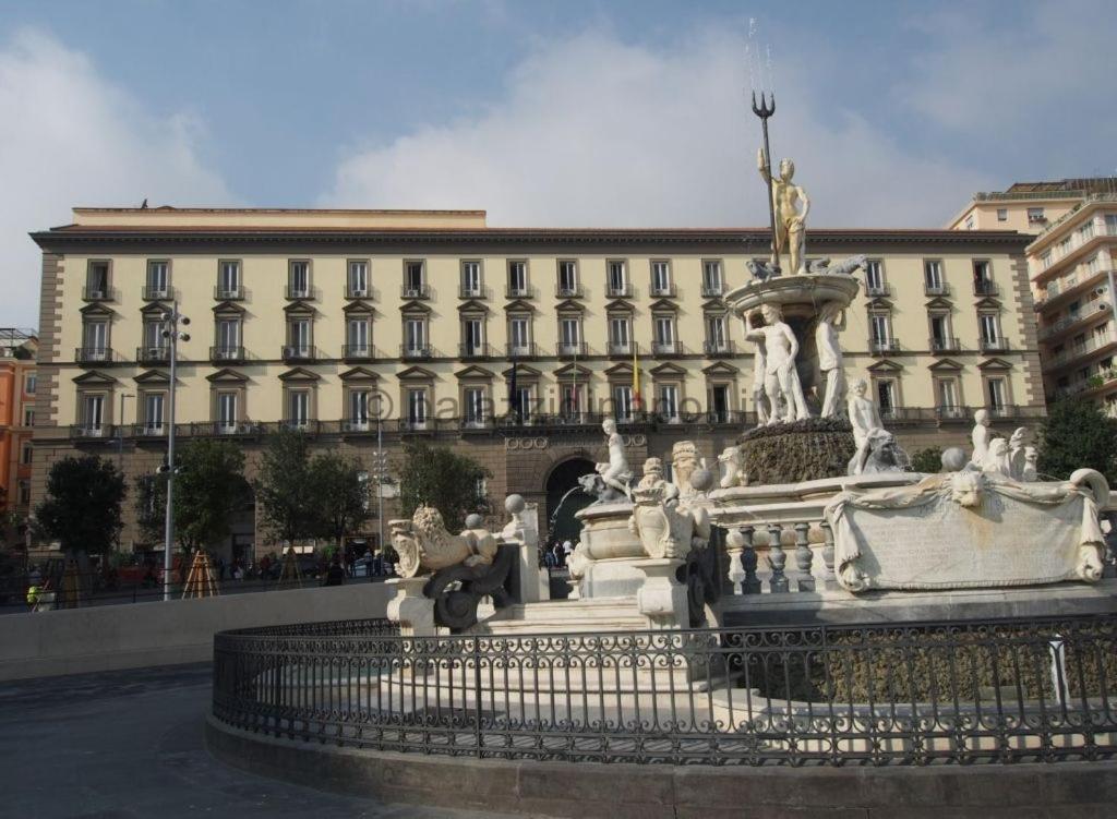 a white fountain in front of a large building at Angioino Central in Naples