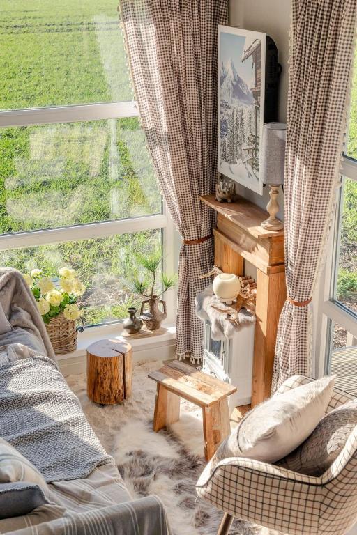 a living room with a couch and a large window at Kemphaontje is a Magic Tiny House with a view in Anloo
