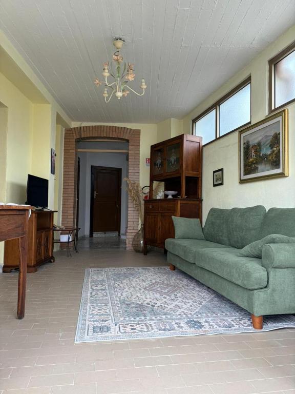 ein Wohnzimmer mit einer grünen Couch und einem Klavier in der Unterkunft U' Cerrito in Orria