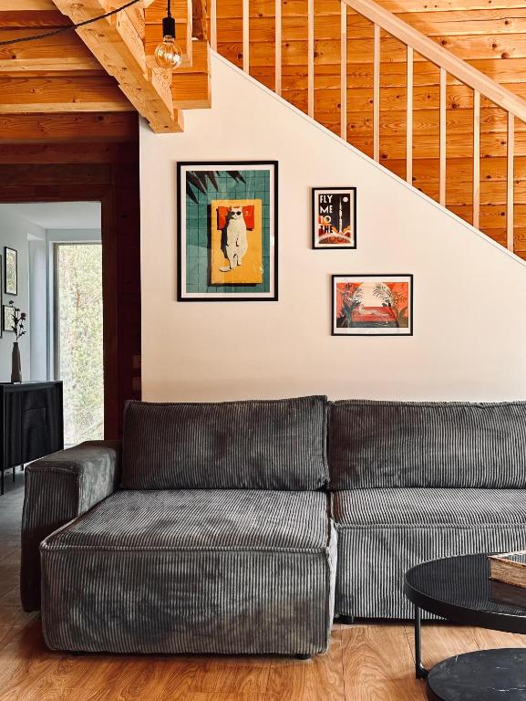 a living room with a couch and a staircase at Silarozes in Mālpils