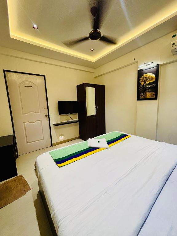 a large white bed in a room with a door at The Royal Samrat Newly renovated in Pune